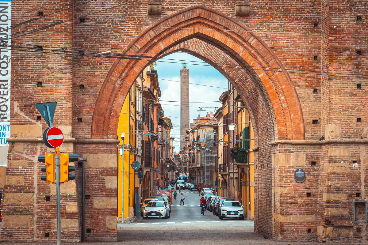 Street at Porta Maggiore in Bologna with a medieval gate tower and pedestrians