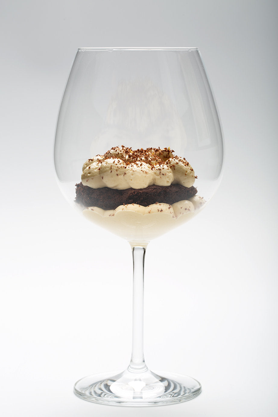 A layered dessert in a wine glass at Comi 107