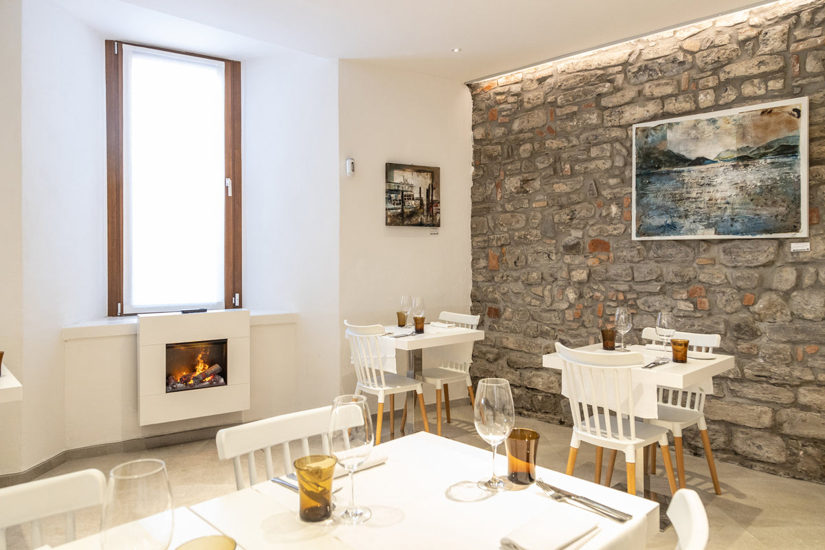 A dining room with fireplace and stone wall at Comi 107