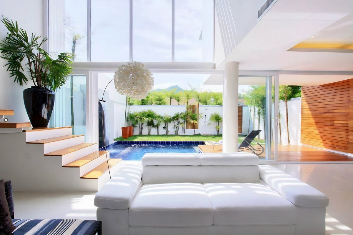 Double-height living room opening onto the pool in a Suksan Homes villa
