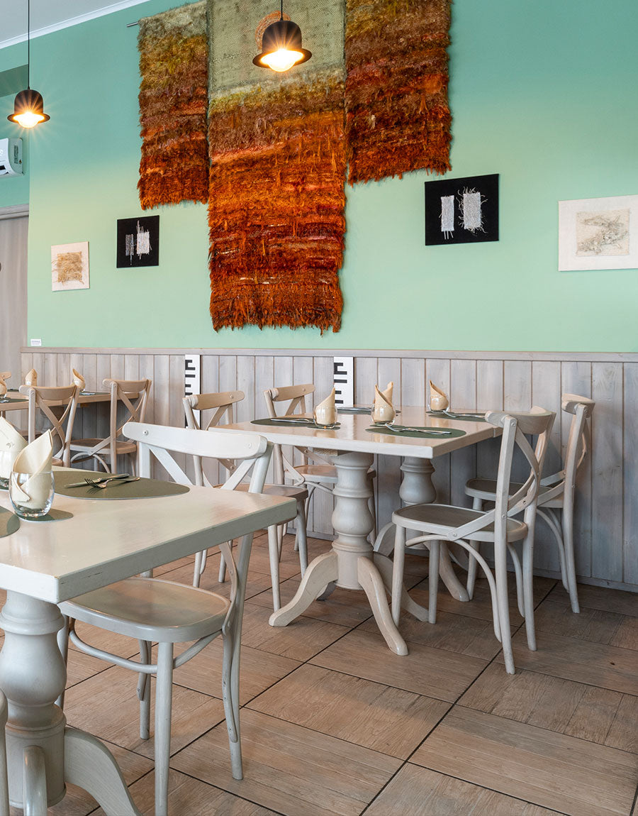 Tables beneath a woven wall hanging at Ciàpa Fiaa