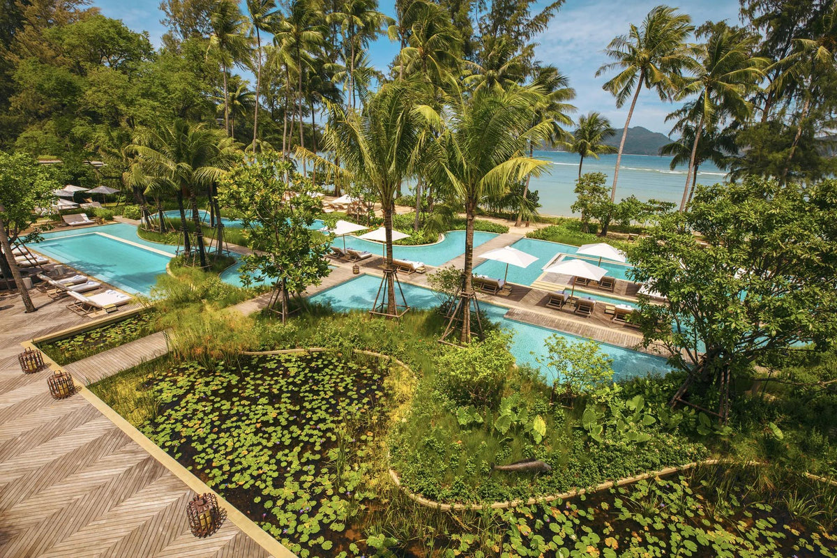 Pool terraces among palms and lily ponds at Rosewood Phuket