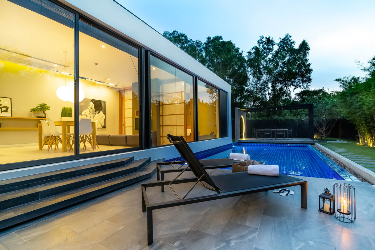Pool terrace with loungers at dusk at Villoft Zen Living