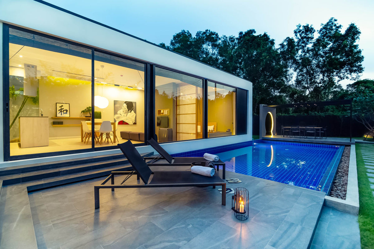 Villoft pool villa with sun loungers in the evening light