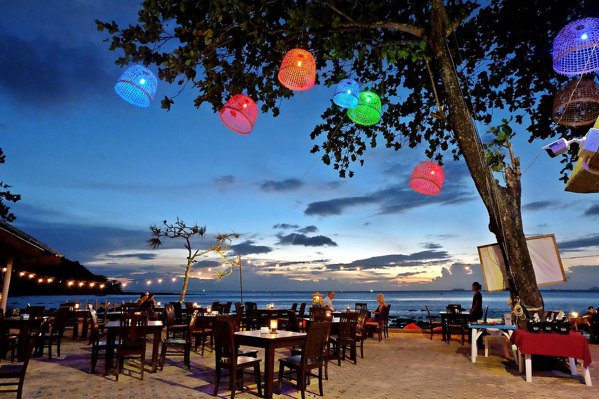 Lantern-lit beachfront tables at 432 Restaurant & Bar at dusk