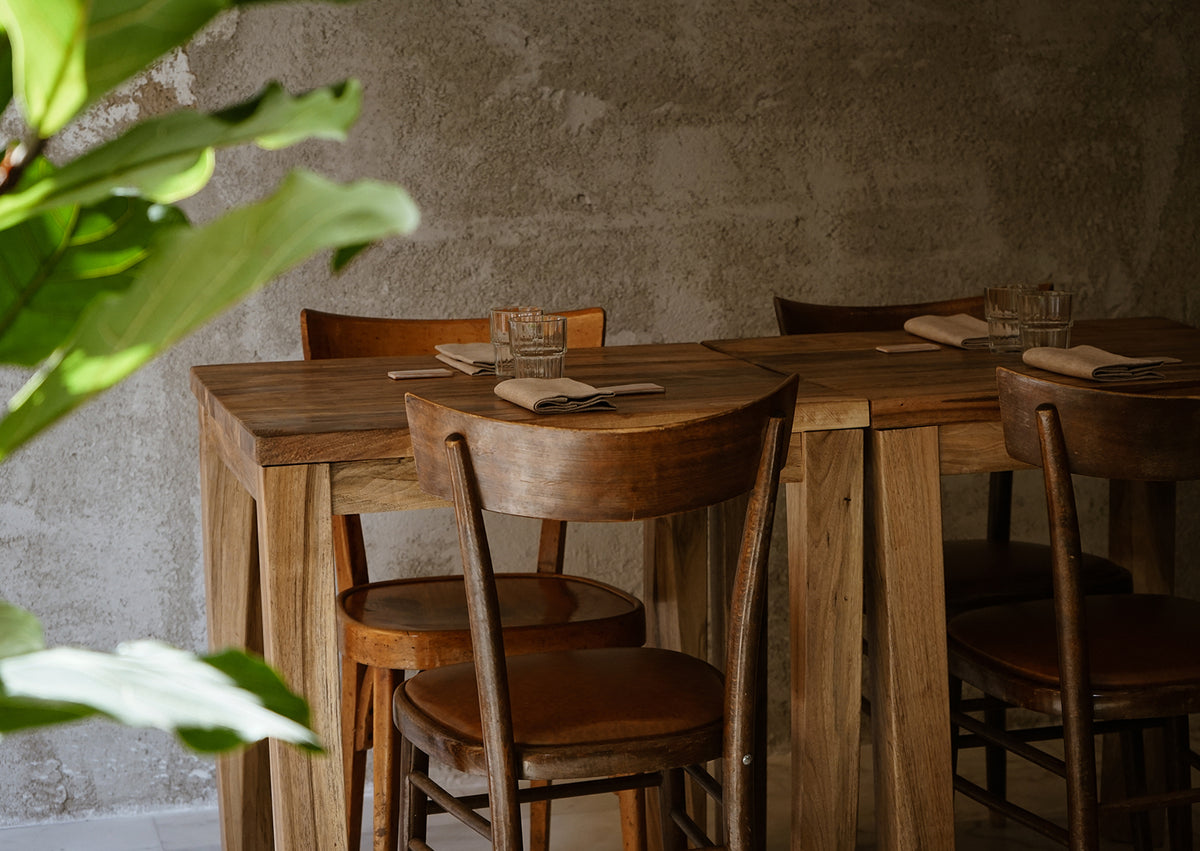 Wooden tables and chairs in the dining room at Ahimè