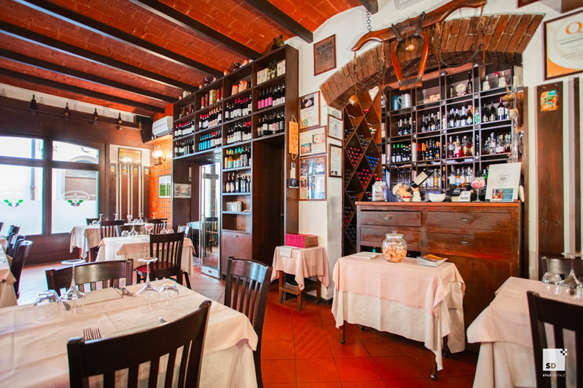 The dining room with laid tables and wine shelves at Al Sangiovese