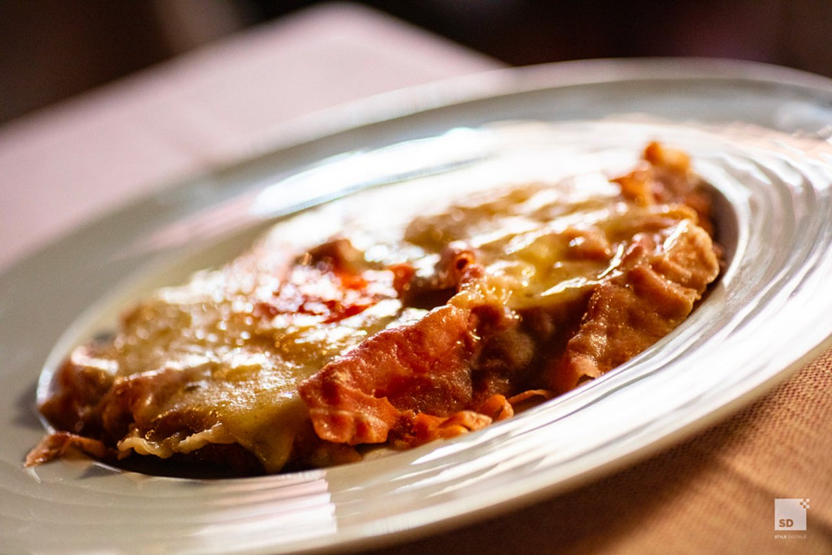 A baked pasta dish with melted cheese at Al Sangiovese