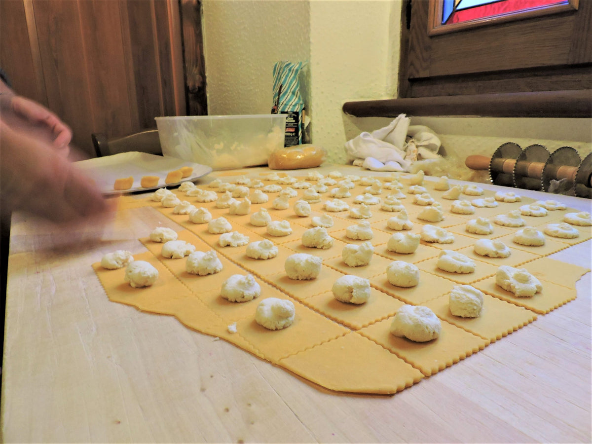 Fresh pasta being filled by hand on a sheet of sfoglia at Dal Biassanot