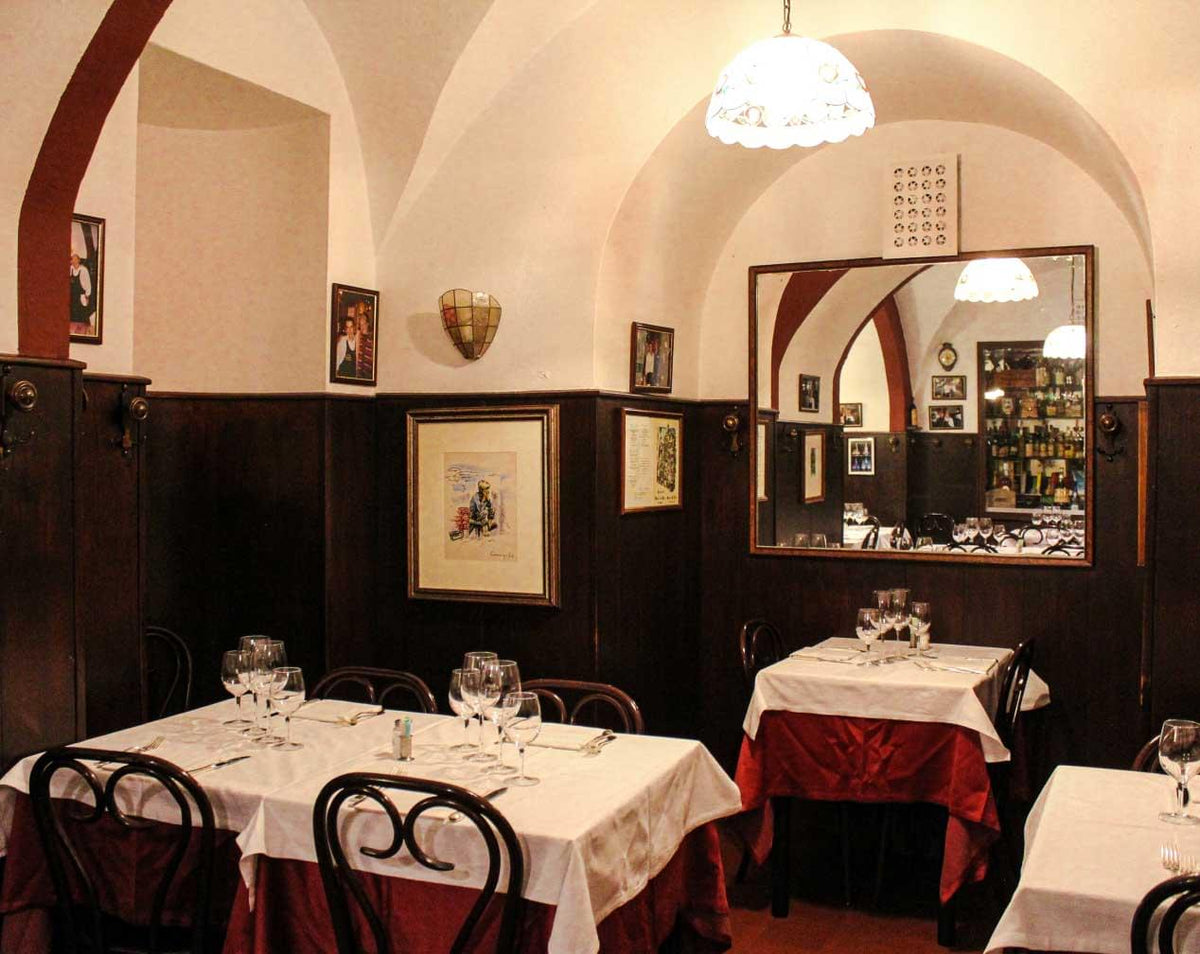A dining room with vaulted ceiling and set tables at Da Nello