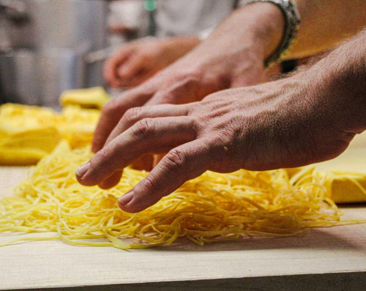 Freshly cut egg pasta on a wooden board at Da Nello