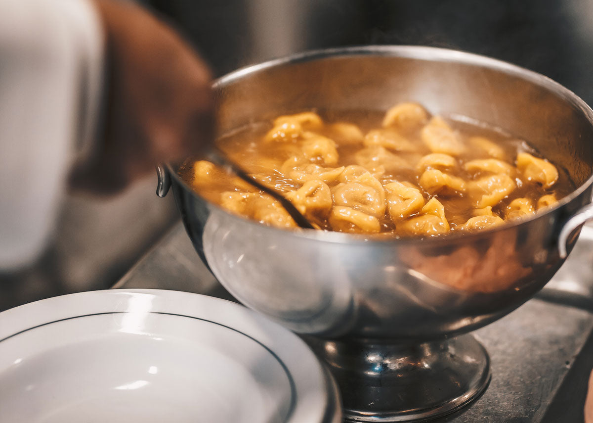 Tortellini in broth served from a silver tureen at Diana