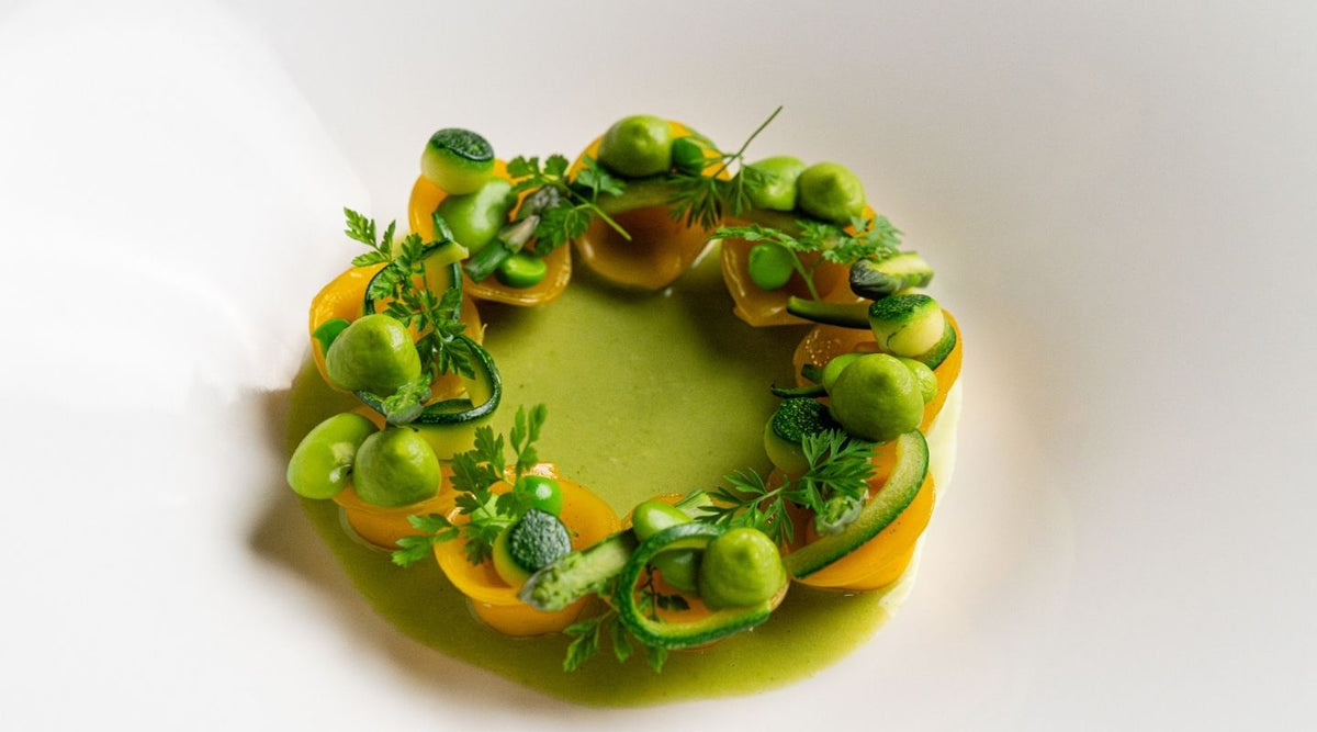 A ring of green vegetables around a green sauce at I Carracci