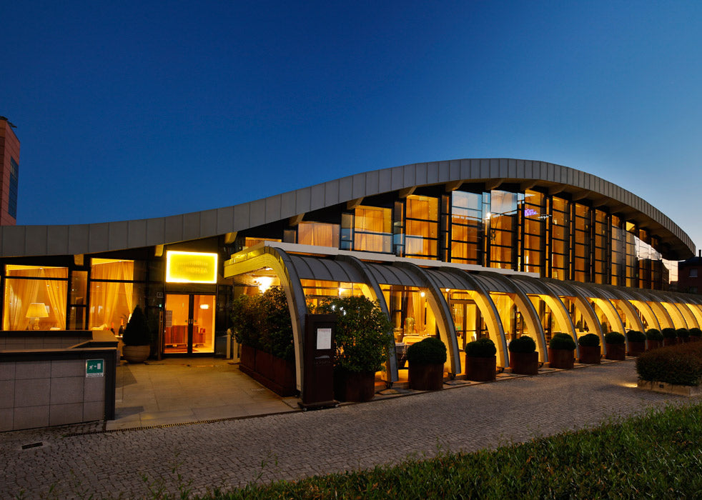 The illuminated glass façade at dusk at La Porta