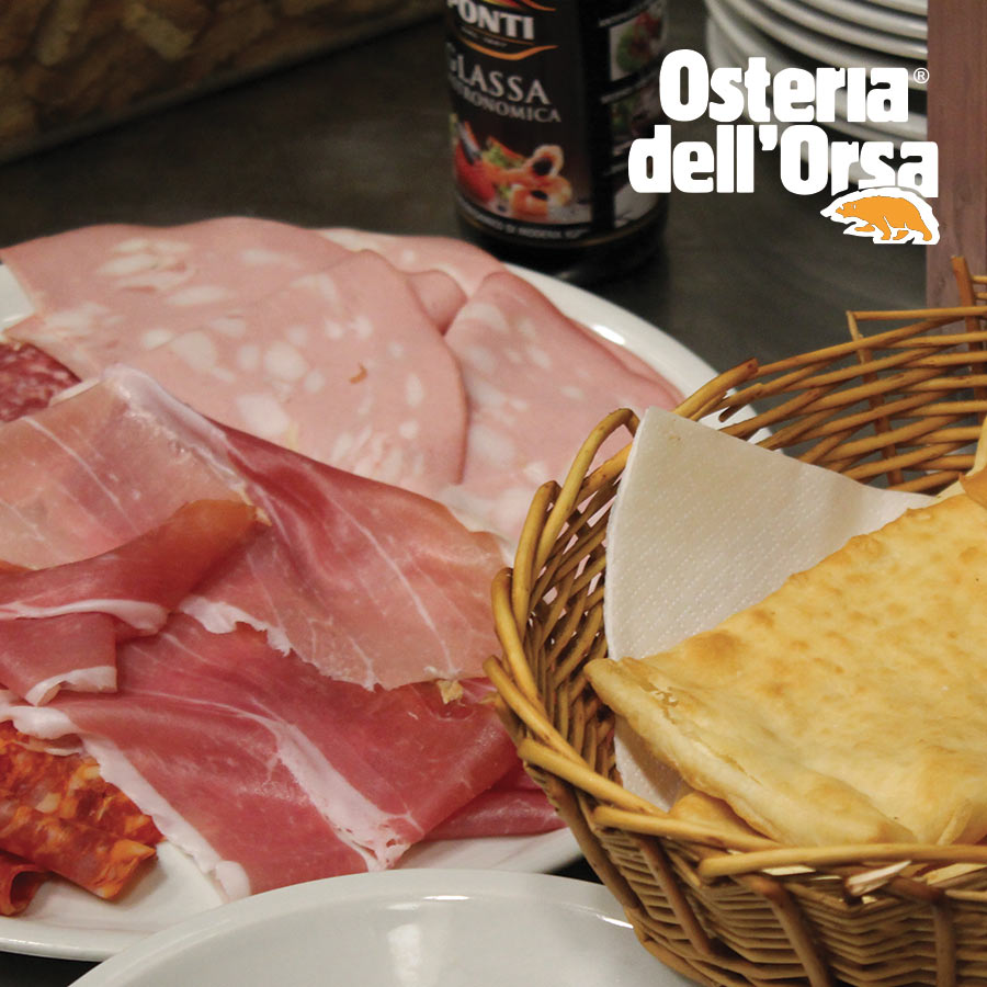 Sliced cured meats with a basket of flatbread at Osteria dell'Orsa