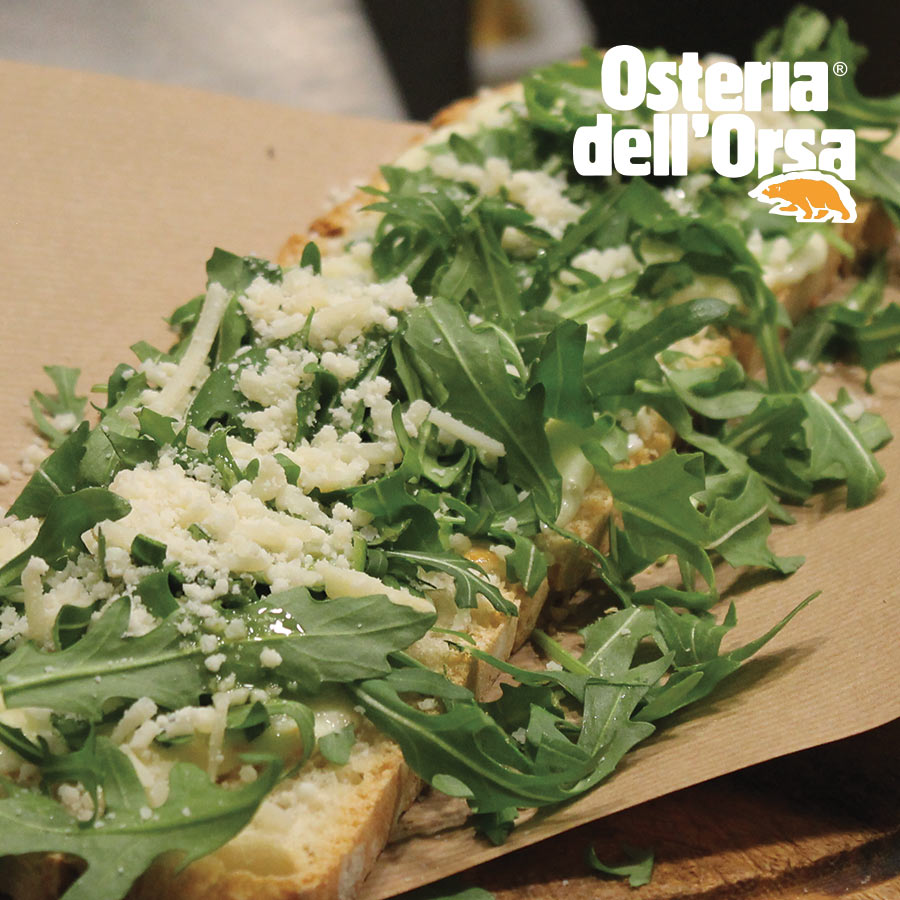 Bruschetta topped with rocket and grated cheese at Osteria dell'Orsa