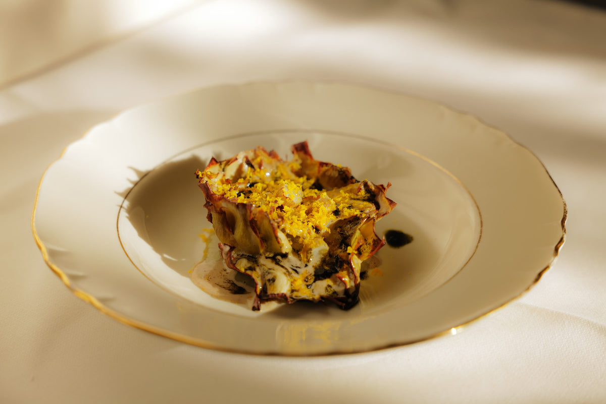A layered dish on a gold-rimmed plate at Scacco Matto
