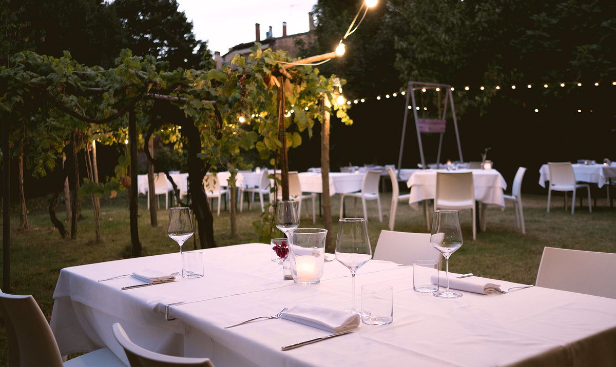 Tables in the garden at Scacco Matto agli Orti, under string lights