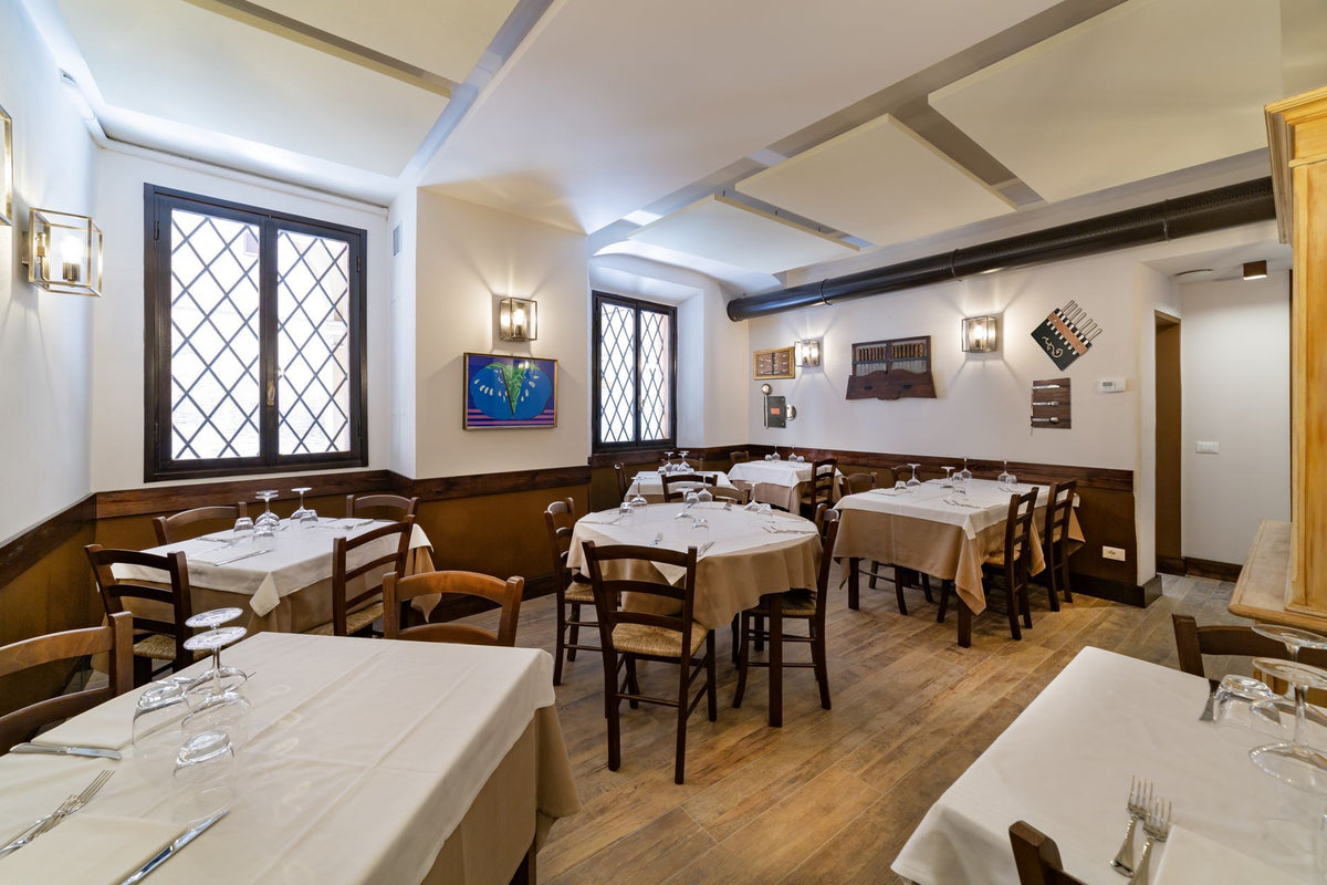 The dining room with tables set for lunch at Trattoria della Santa