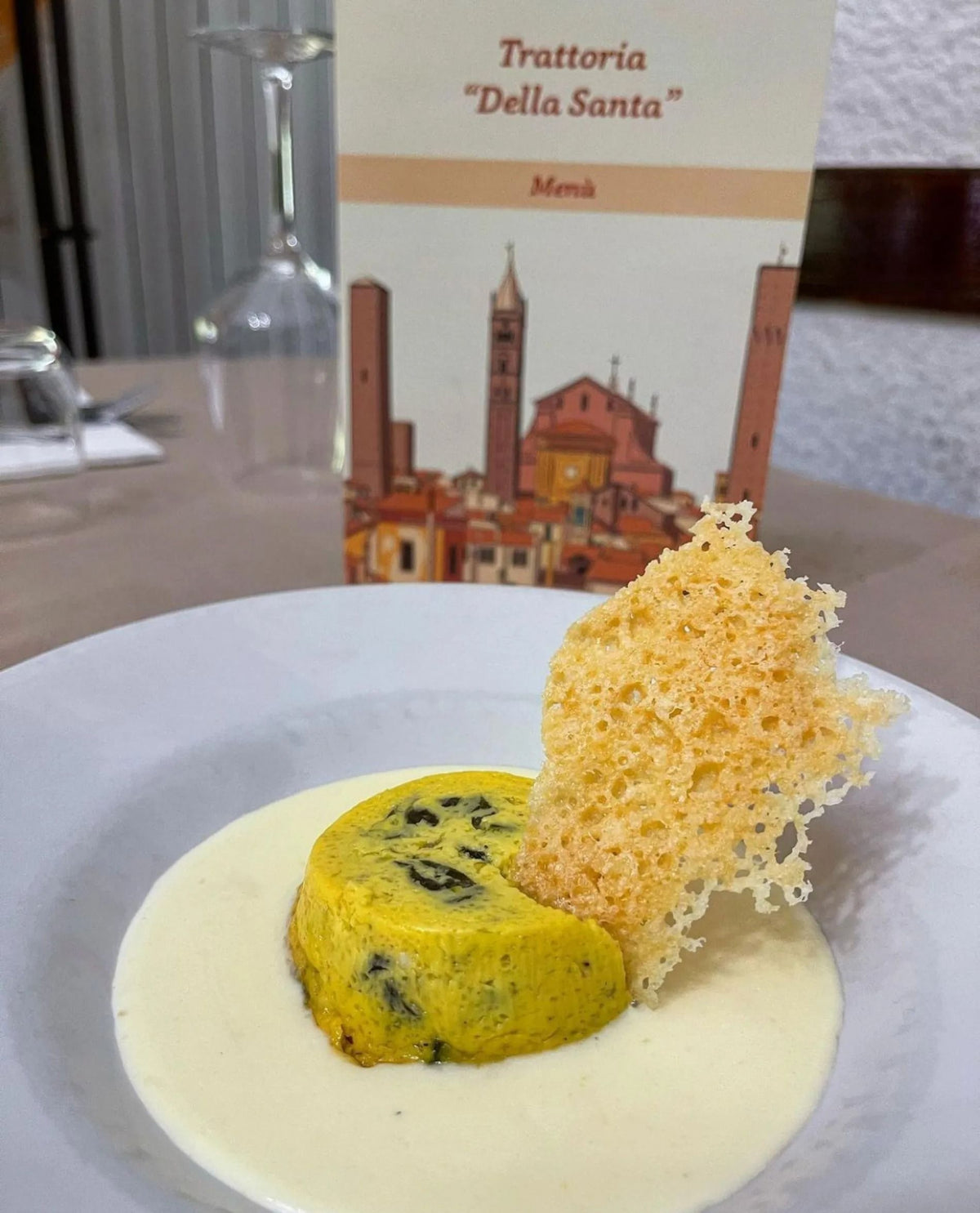 A flan with a Parmesan crisp on a cream sauce at Trattoria della Santa
