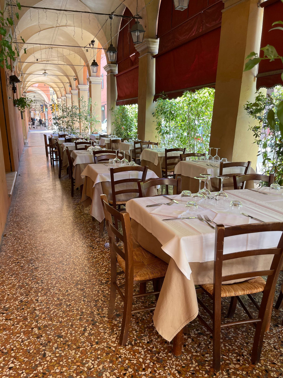 Tables set under the portico at Trattoria della Santa