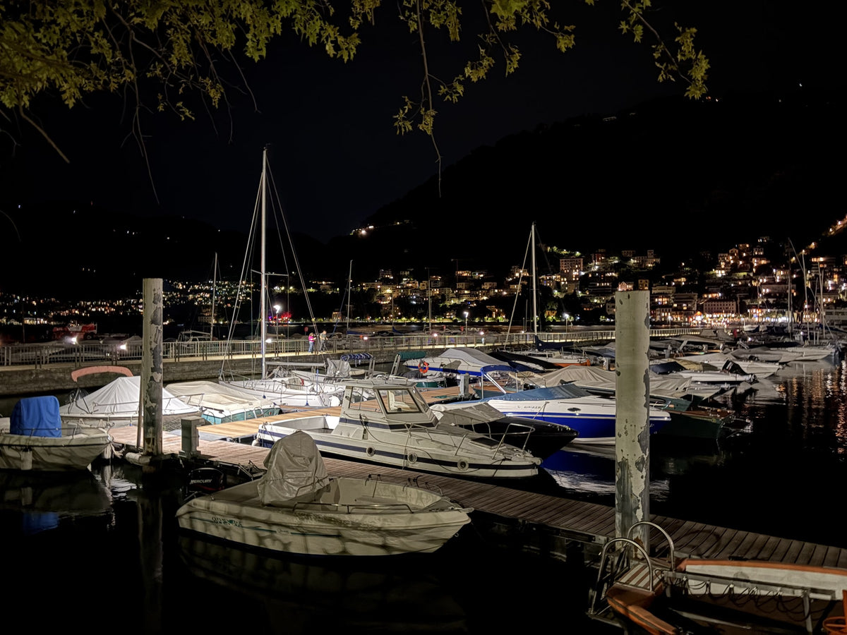 Como's harbour at night, with the lights of Brunate above