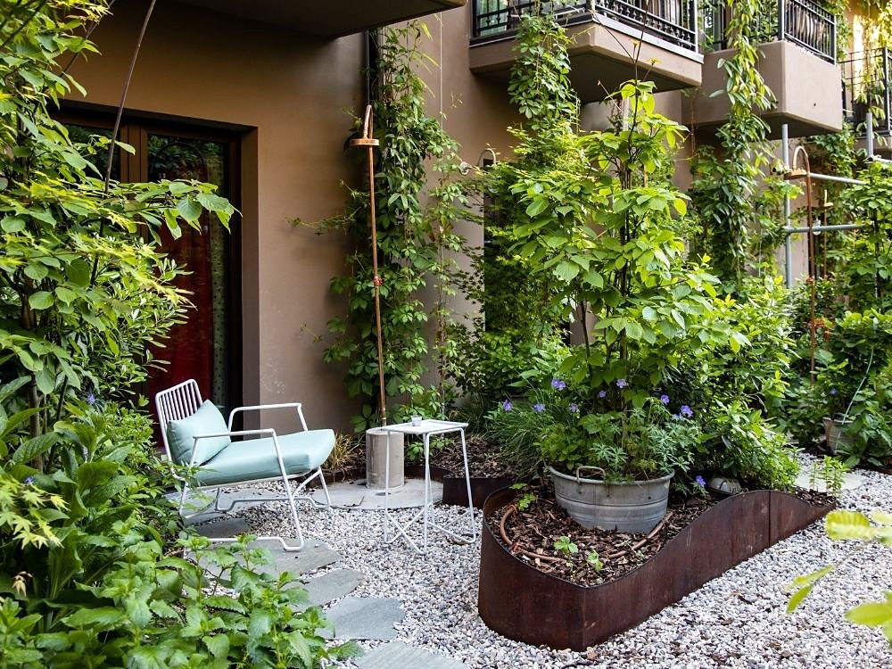 Leafy private garden terrace of a ground-floor room at 25hours Hotel Florence