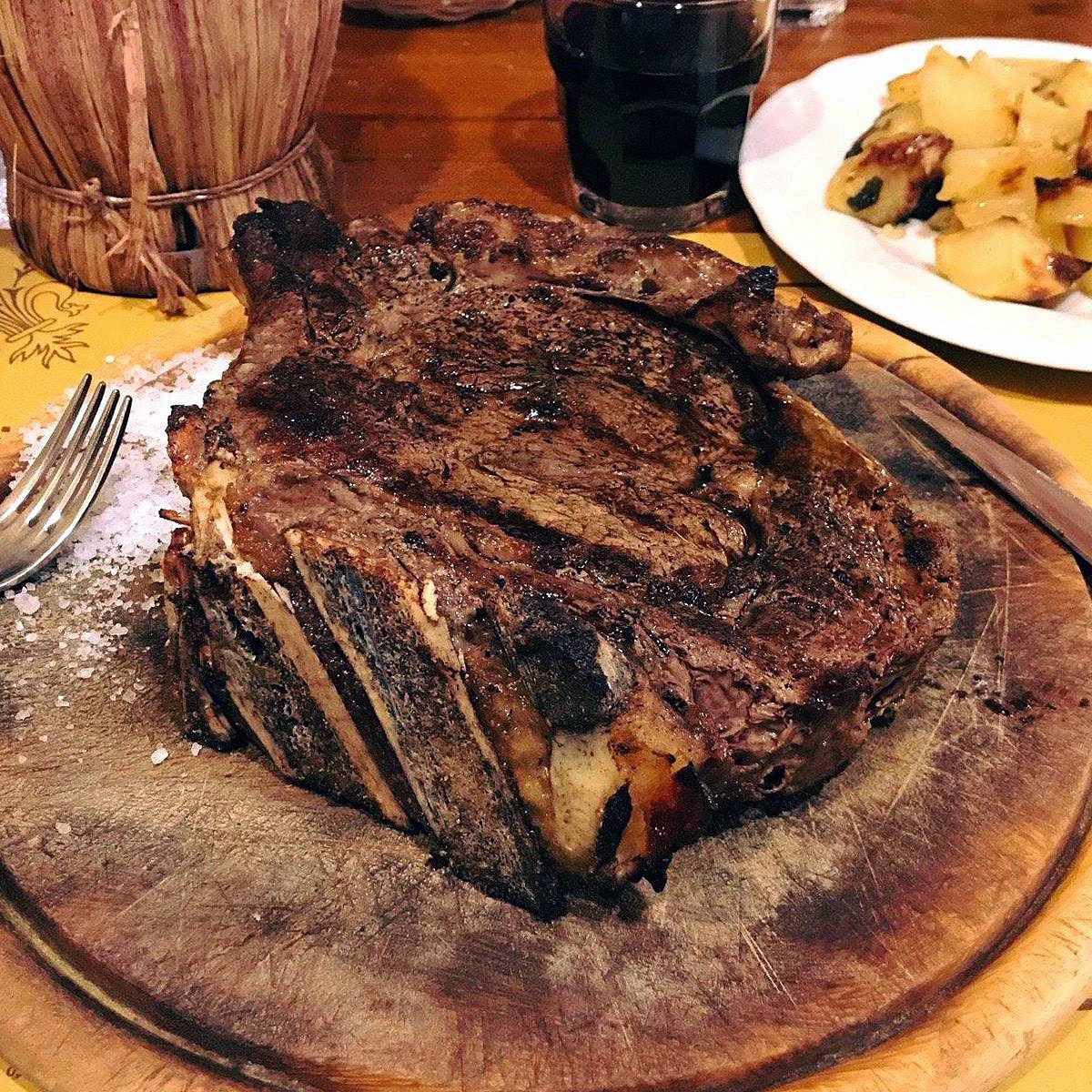 Bistecca alla fiorentina on a wooden board at Antico Ristoro di Cambi