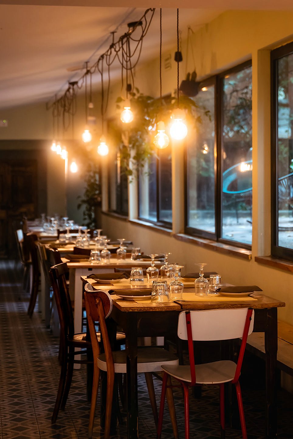 Lamp-lit dining room with laid tables at Braciere Malatesta
