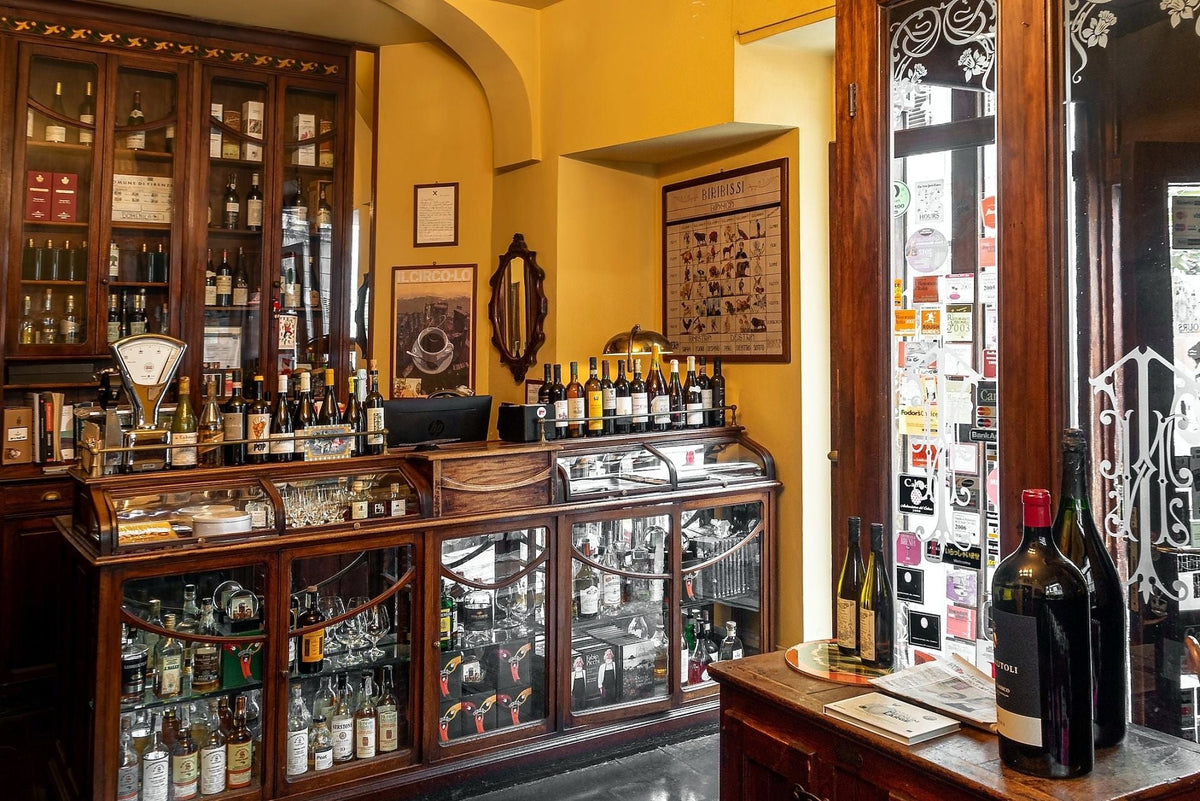 Wood-panelled bar counter lined with bottles at Cibrèo Ristorante