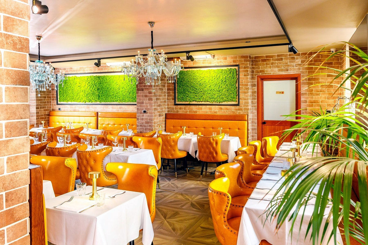 Dining room with orange leather chairs and chandeliers at Ciro & Sons
