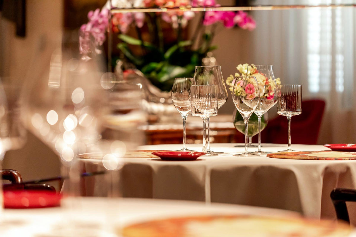 Table laid with glassware and flowers in the dining room of Enoteca Pinchiorri