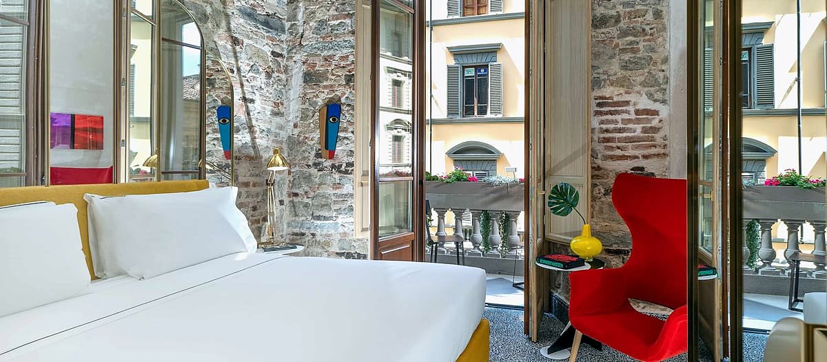 Bright room with French windows opening onto a balcony at Hotel Calimala