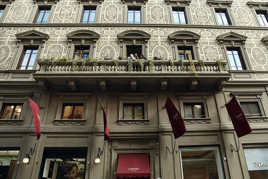 Decorated historic façade of Hotel Calimala with its burgundy banners