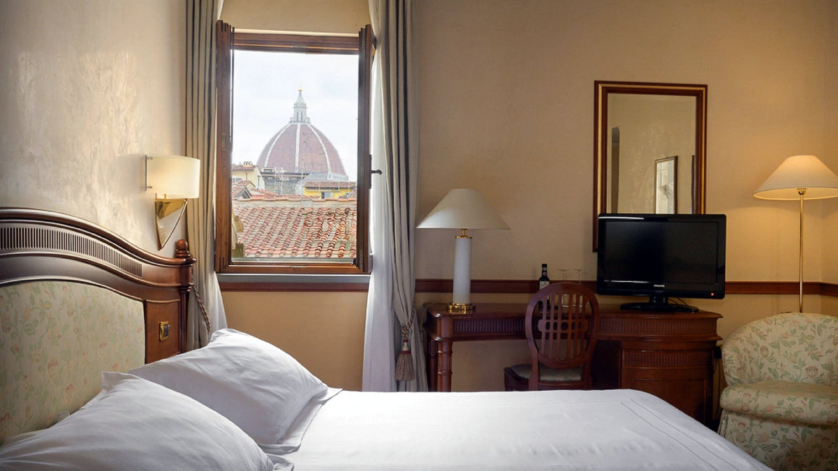 Double room with a window framing the Duomo at Hotel degli Orafi