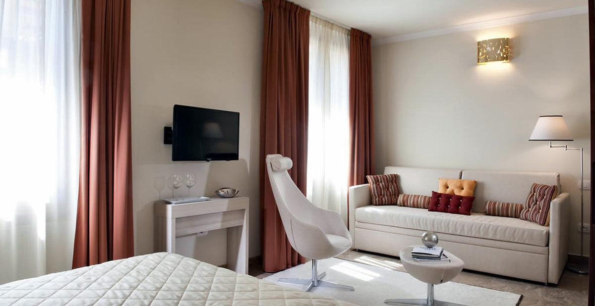 Deluxe room with sofa and lounge chair at Hotel della Signoria