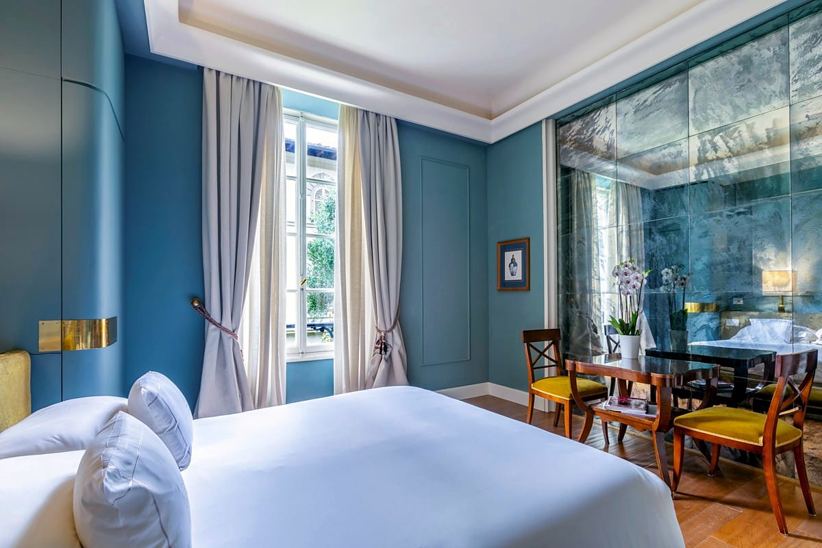 Deluxe room with mirrored wall and dining table at Hotel Regency