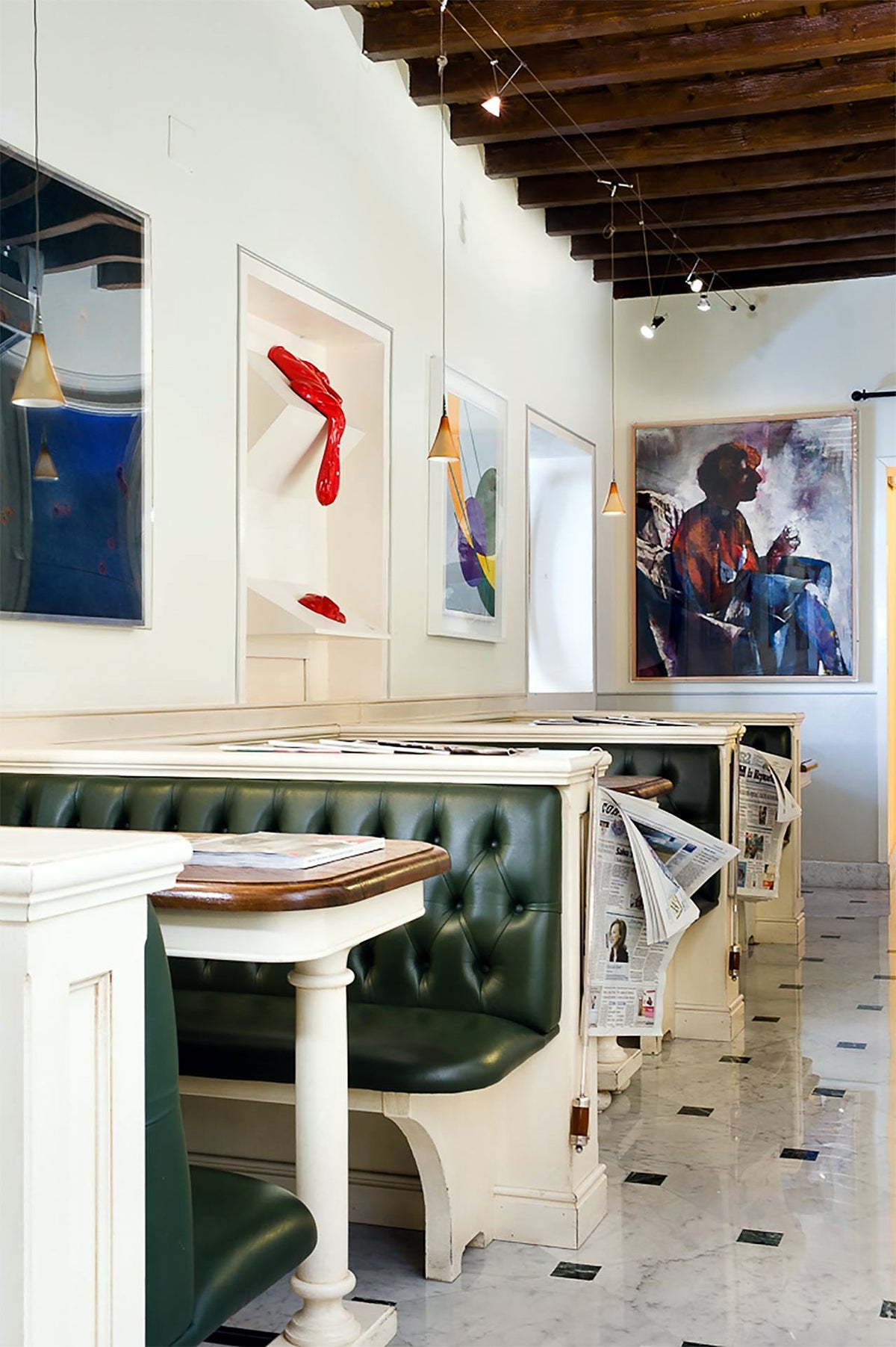 Reading room with contemporary art and green banquettes at Il Guelfo Bianco
