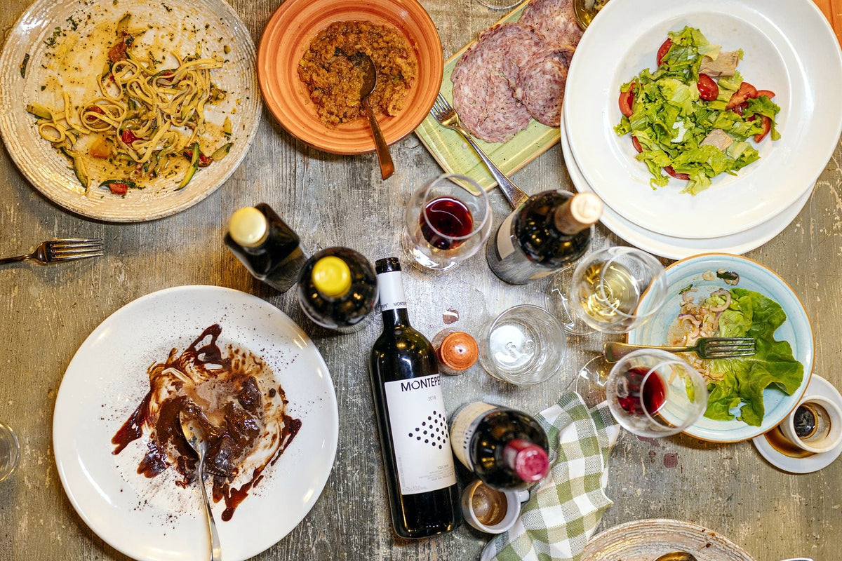 Table of pasta, salads, cured meats and wine at Osteria Cipolla Rossa