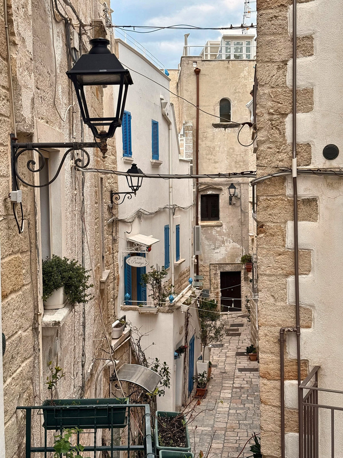Lanterns and blue shutters along a narrow alley