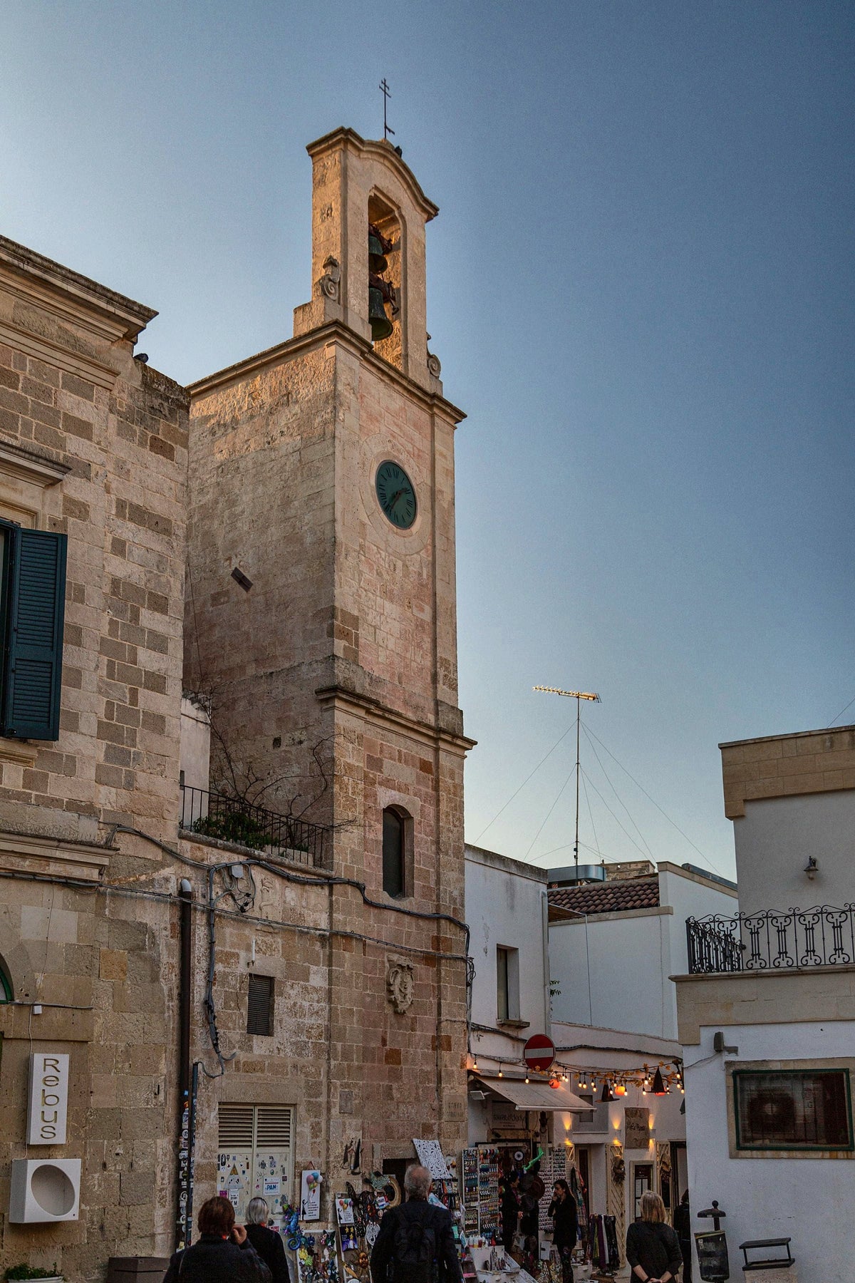 A historic clock tower in Bari at twilight