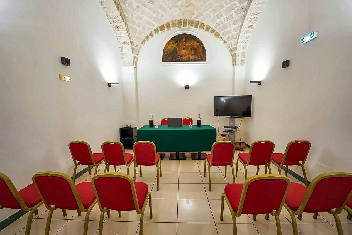 Vaulted meeting room with red chairs at Hotel Adria