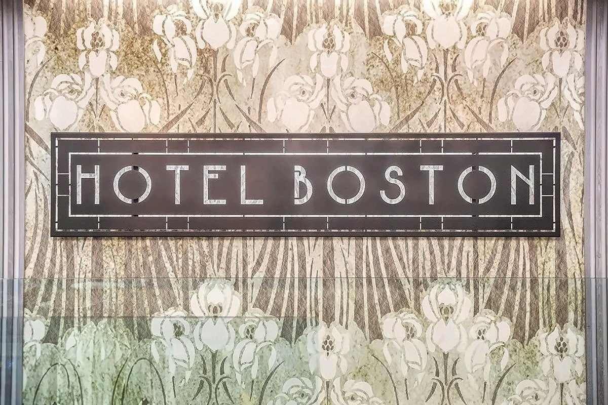 The Art Nouveau-style lettering of Hotel Boston on a floral wall panel
