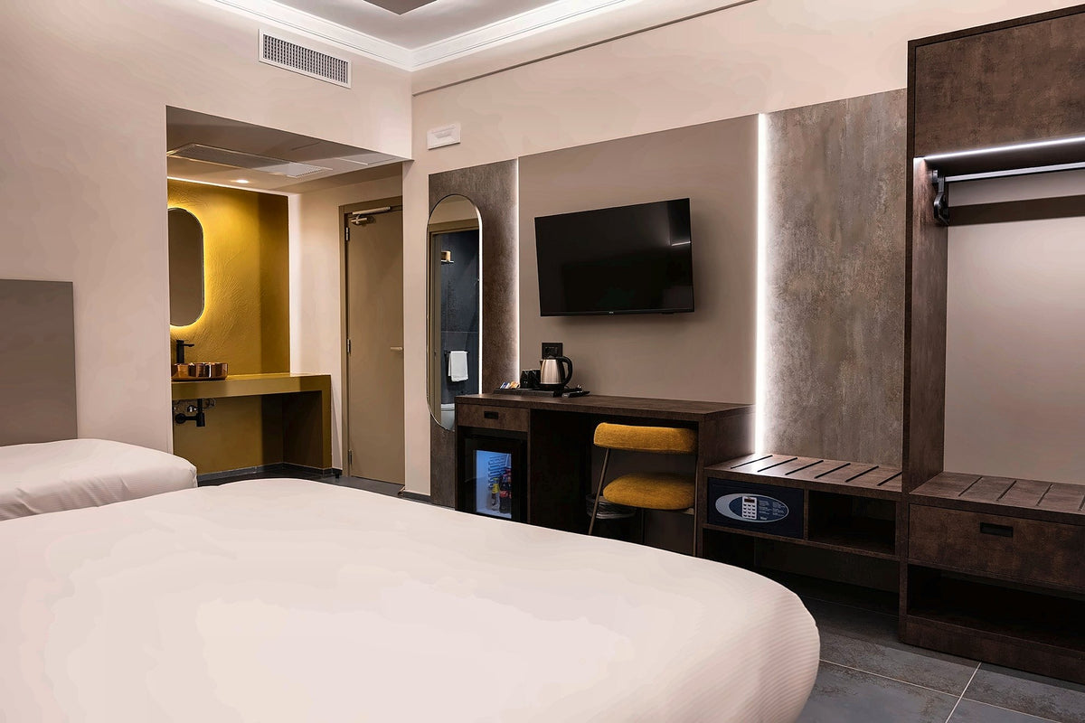 Deluxe room at Hotel Moderno with an ochre-tiled wall and backlit mirror