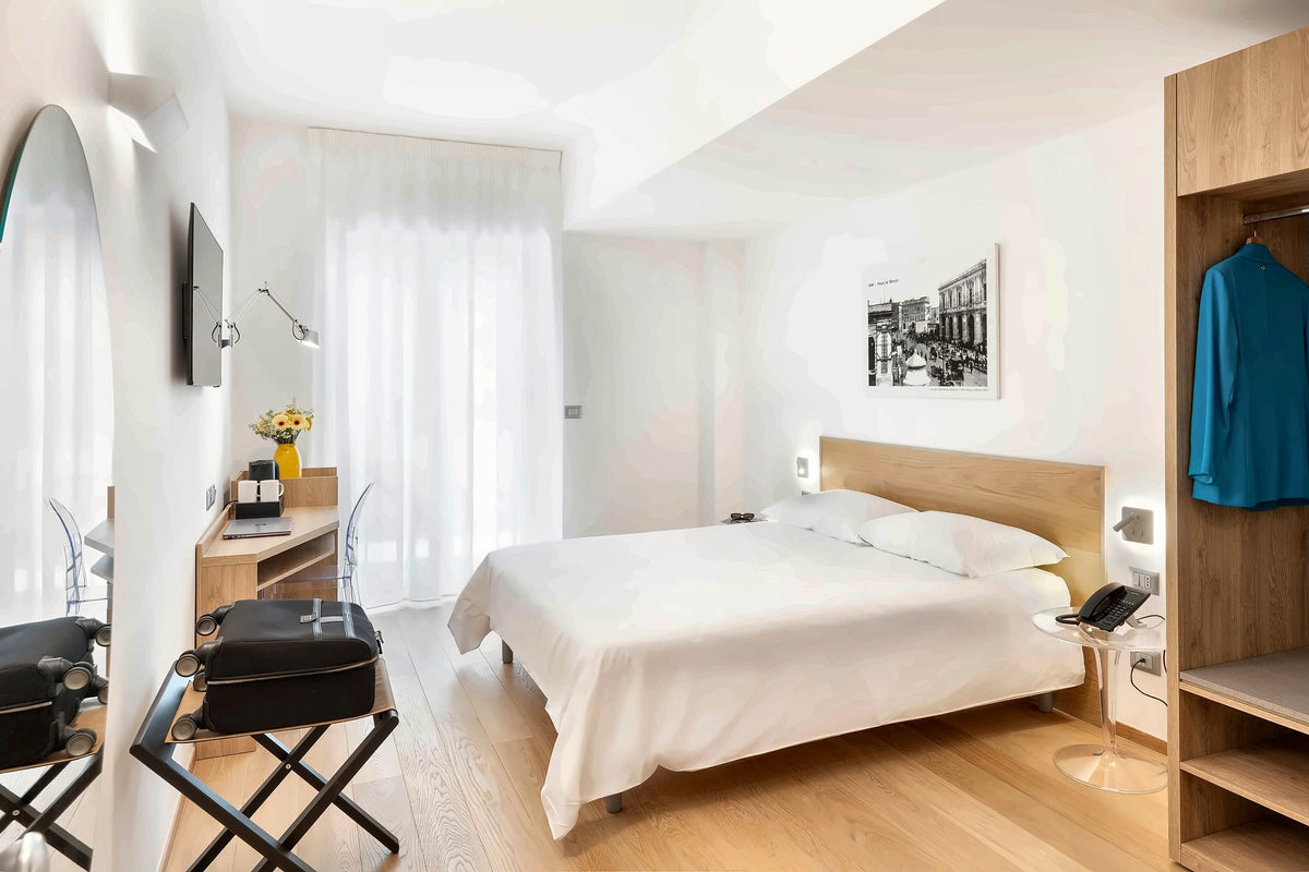A light-filled double room at Victor Hotel Bari with an old photo of the city