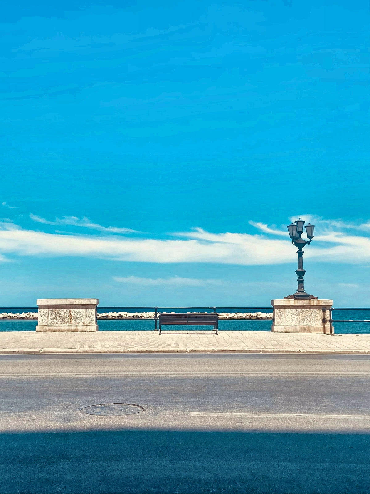A bench and a cast-iron lamp on the seafront promenade