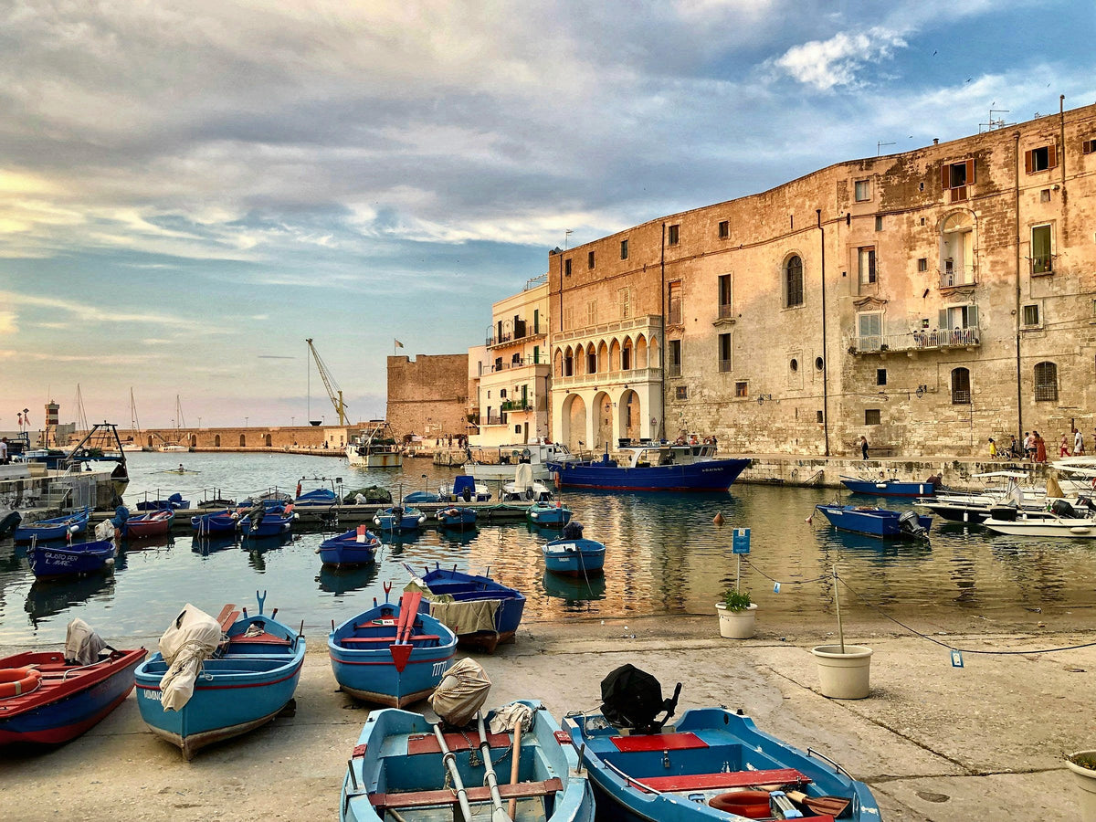 Blue fishing boats in the old port of Monopoli in warm light