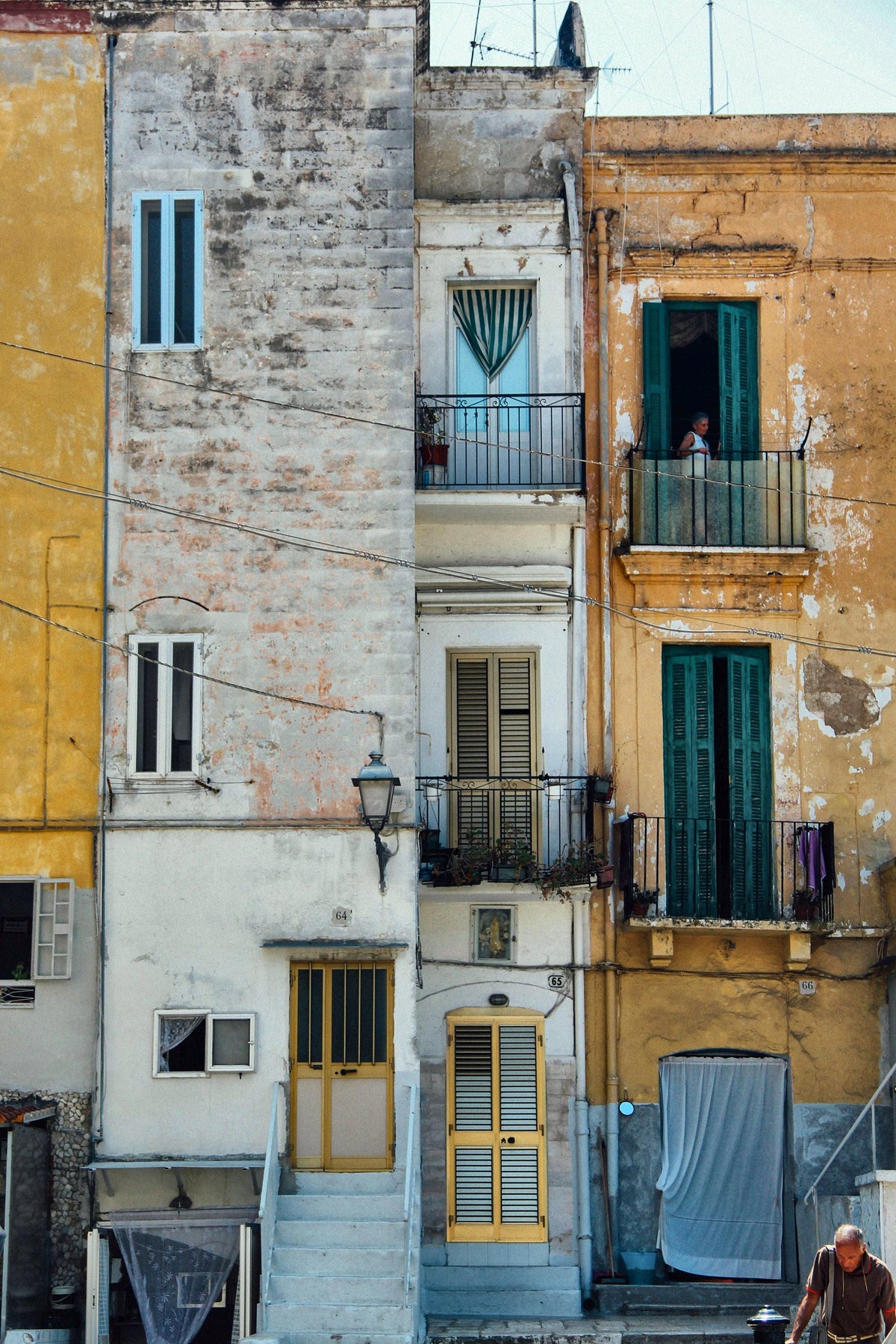 Weathered yellow and white facades with green shutters in the old town