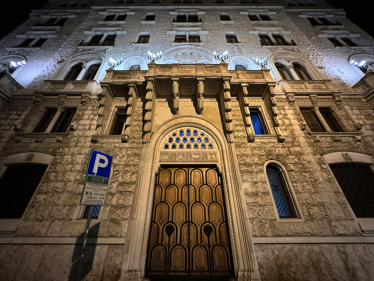 An ornate palazzo facade lit up at night in central Bari