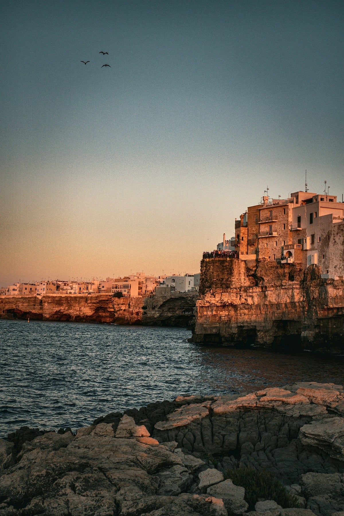 Cliff houses of Polignano a Mare glowing at dusk